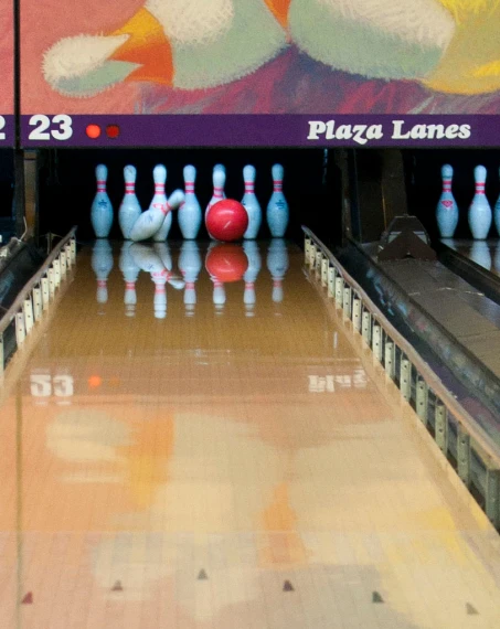 the bowling pins and a ball line up against the wall