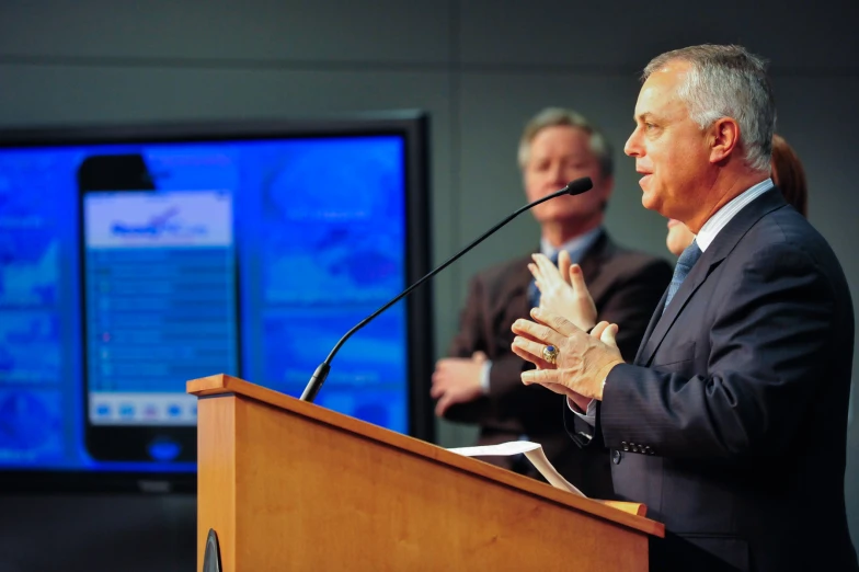 two men wearing business attire standing at a podium