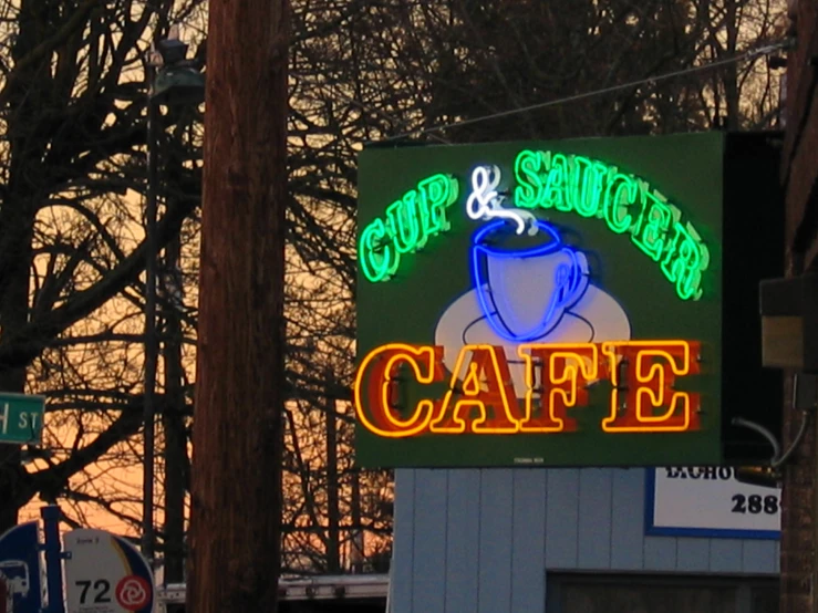 the neon sign outside of an eatery reads cafe