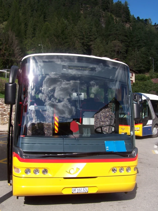 two city buses parked at a parking lot