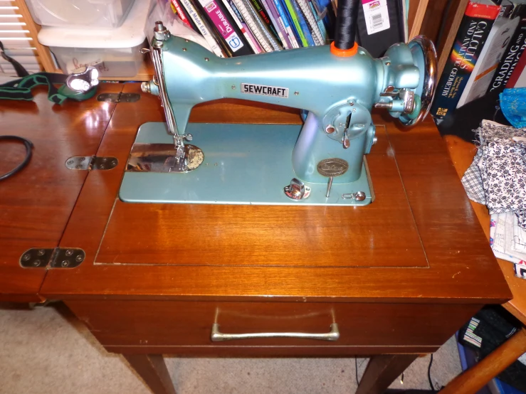 an antique blue sewing machine on a wooden table