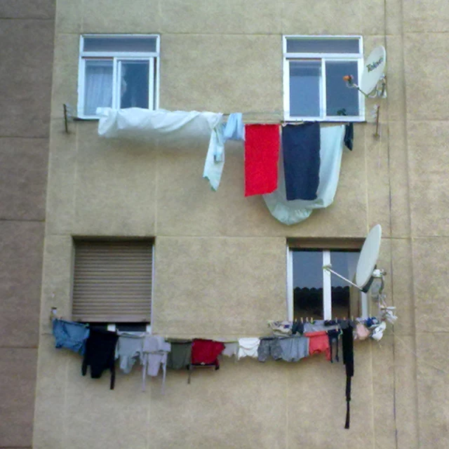 some clothes hanging on the windows and outside a building