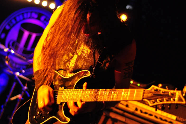 a person with long hair playing a guitar