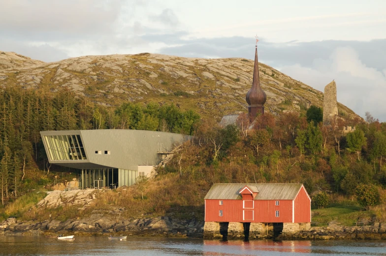 two red wooden buildings on shore of body of water