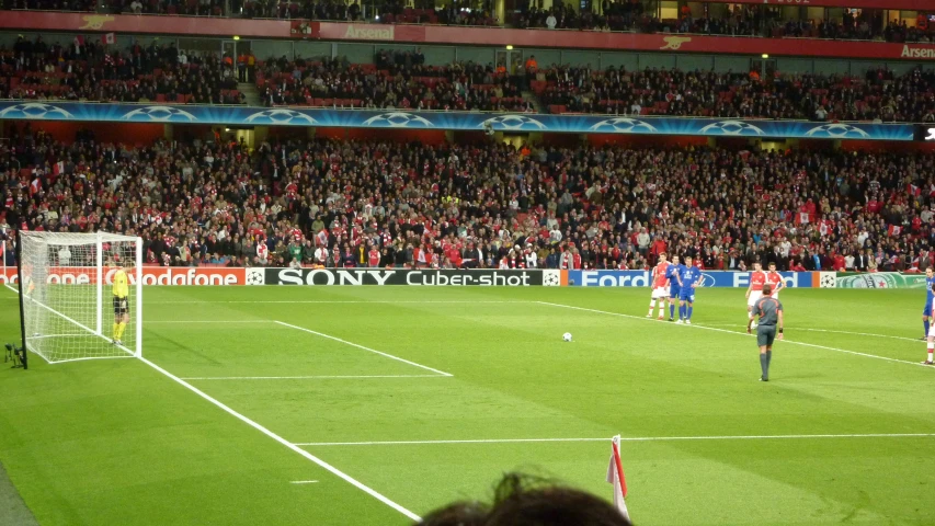 people watch as men play soccer in front of a large crowd