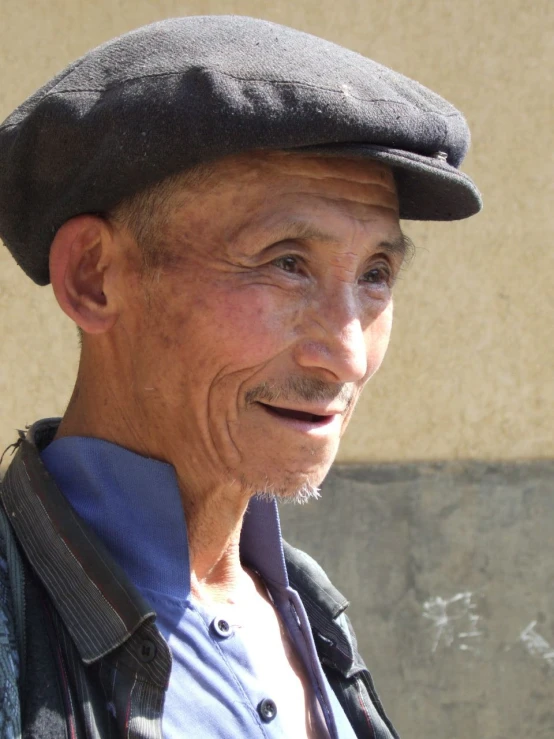 an elderly man with a hat is smiling