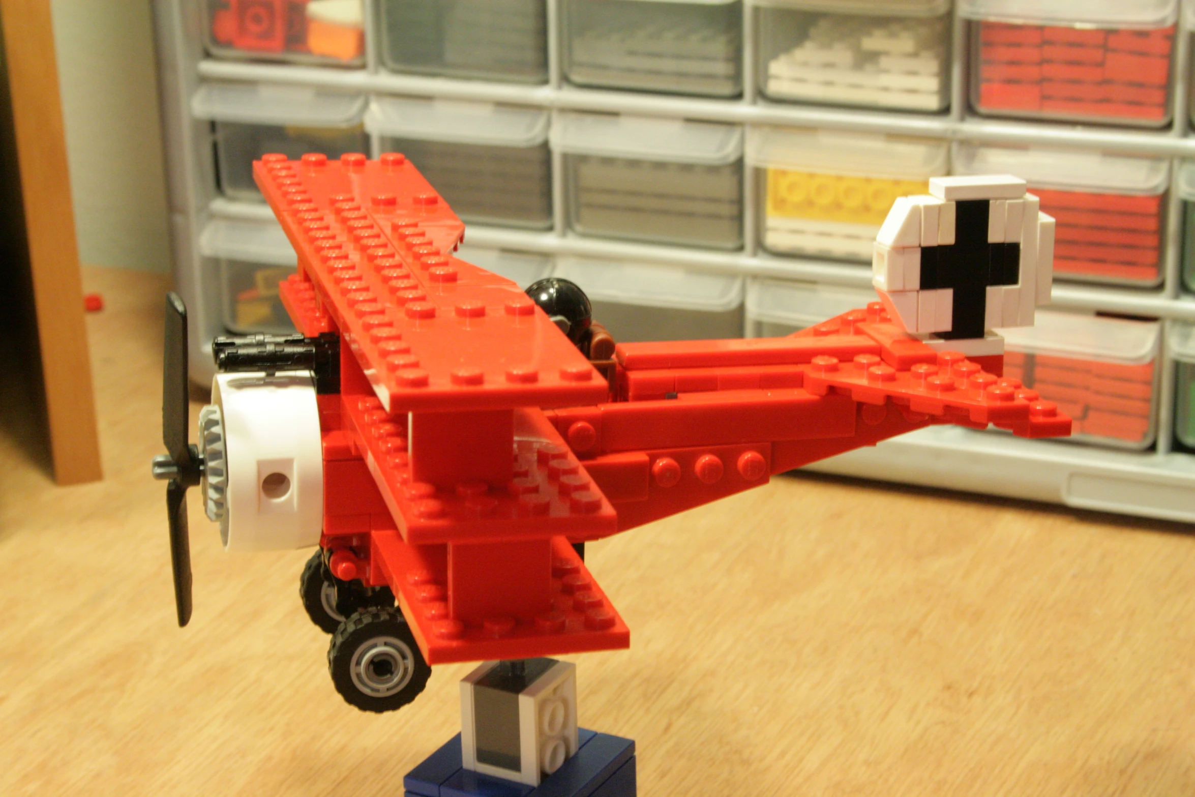 lego toy model red airplane on wooden floor