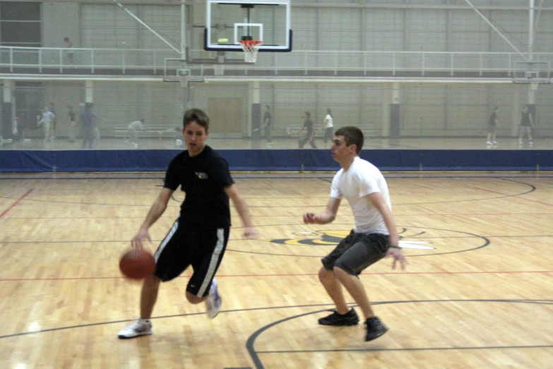 two men playing basketball in the gym