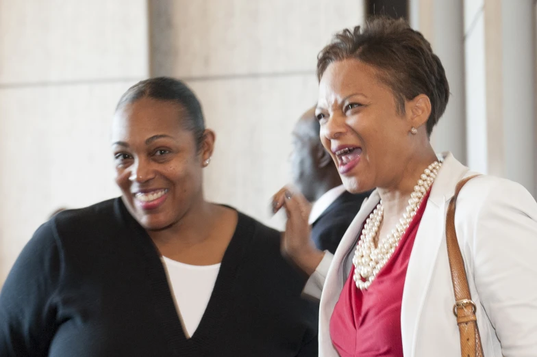 two women standing together smiling at the camera