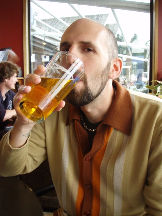 a man sipping a beer in an empty restaurant