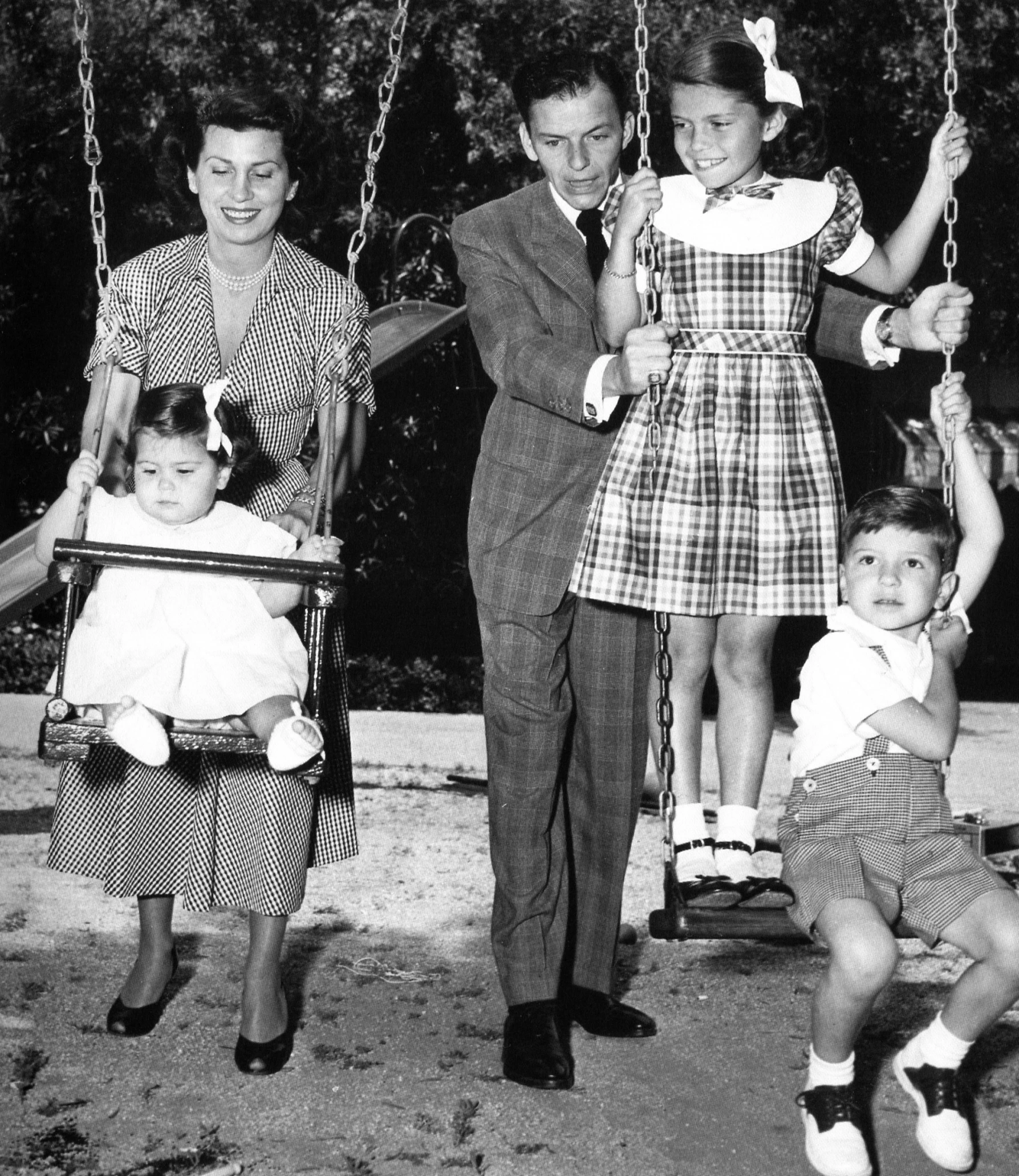 the family poses for a picture on their swing set