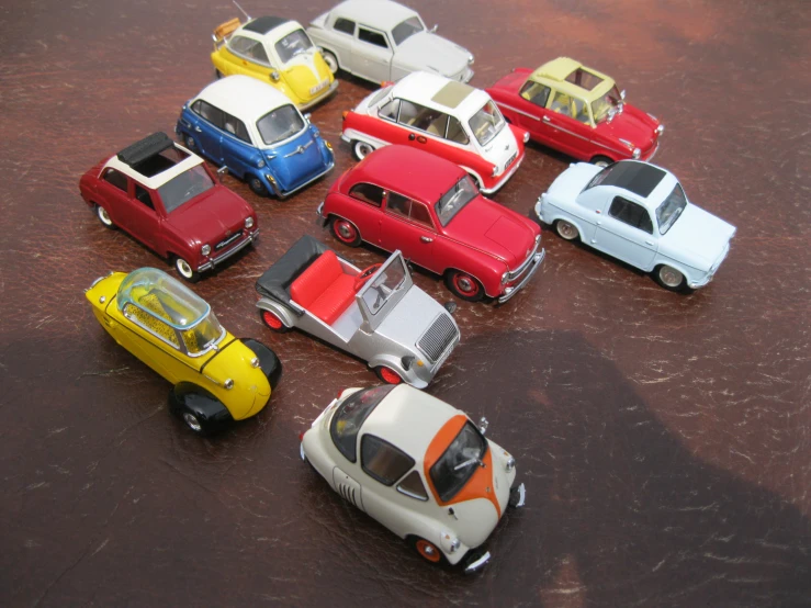 assortment of model car toy cars in a row on a table