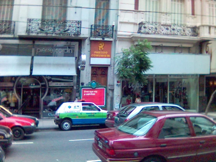 several cars parked on a city street near an apartment building