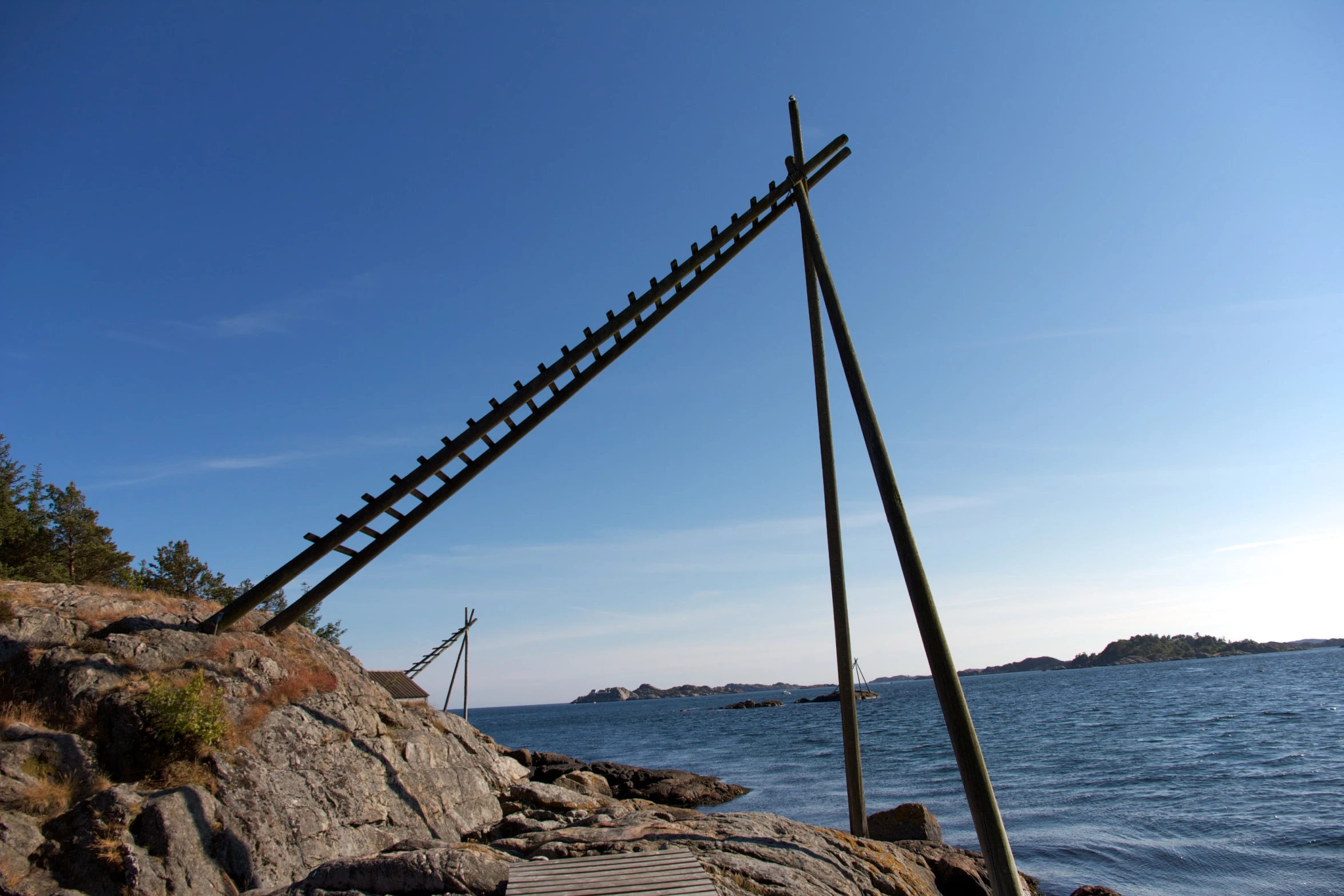 a ladder is in the water near some rocks