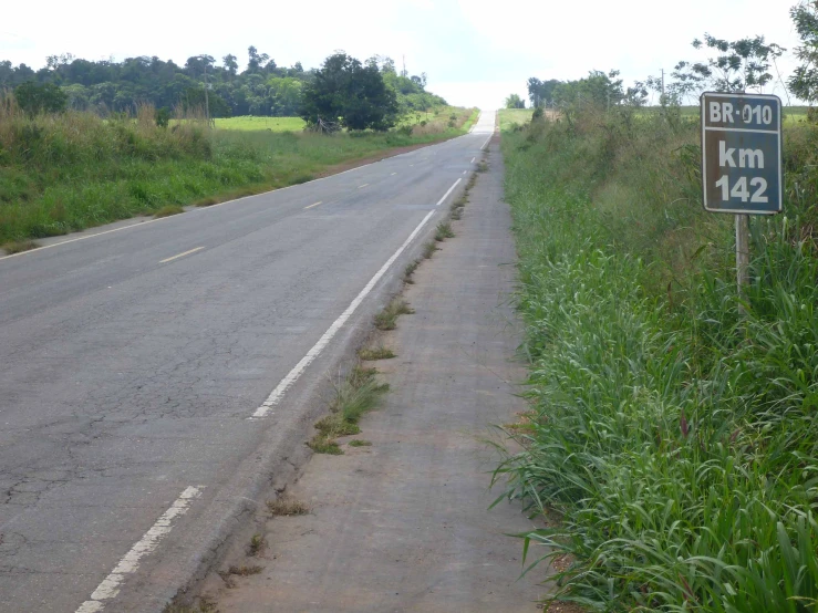 two lane, narrow road with a speed limit sign