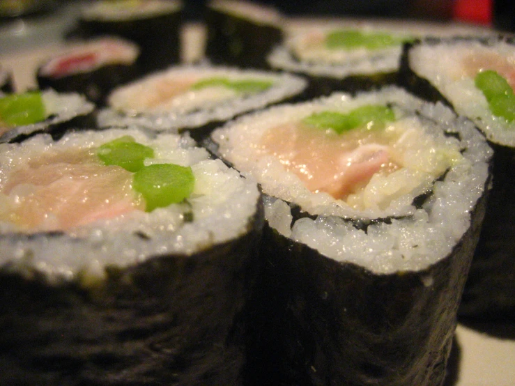 several sushi rolls with meat and green vegetables