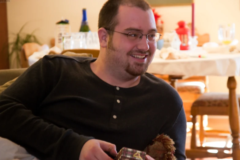 a man holding an item and smiling in a room