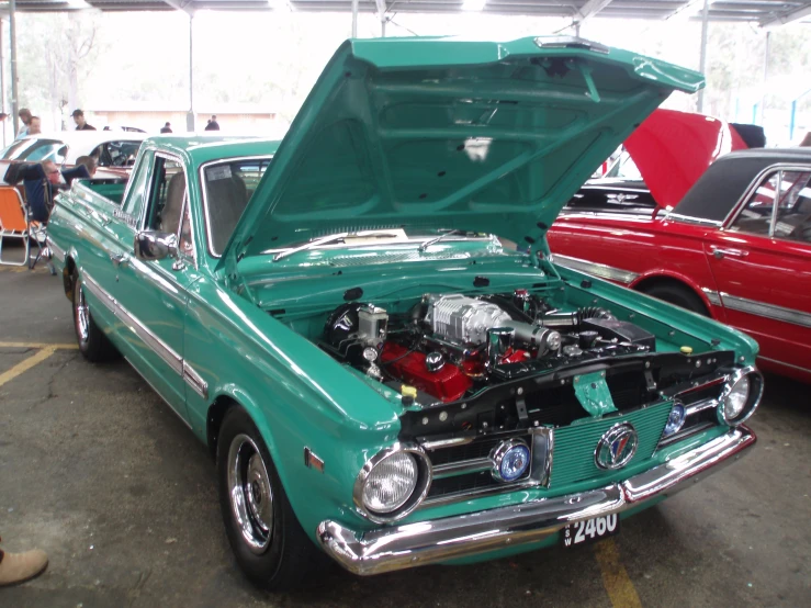 a green classic truck with an engine in it's hood