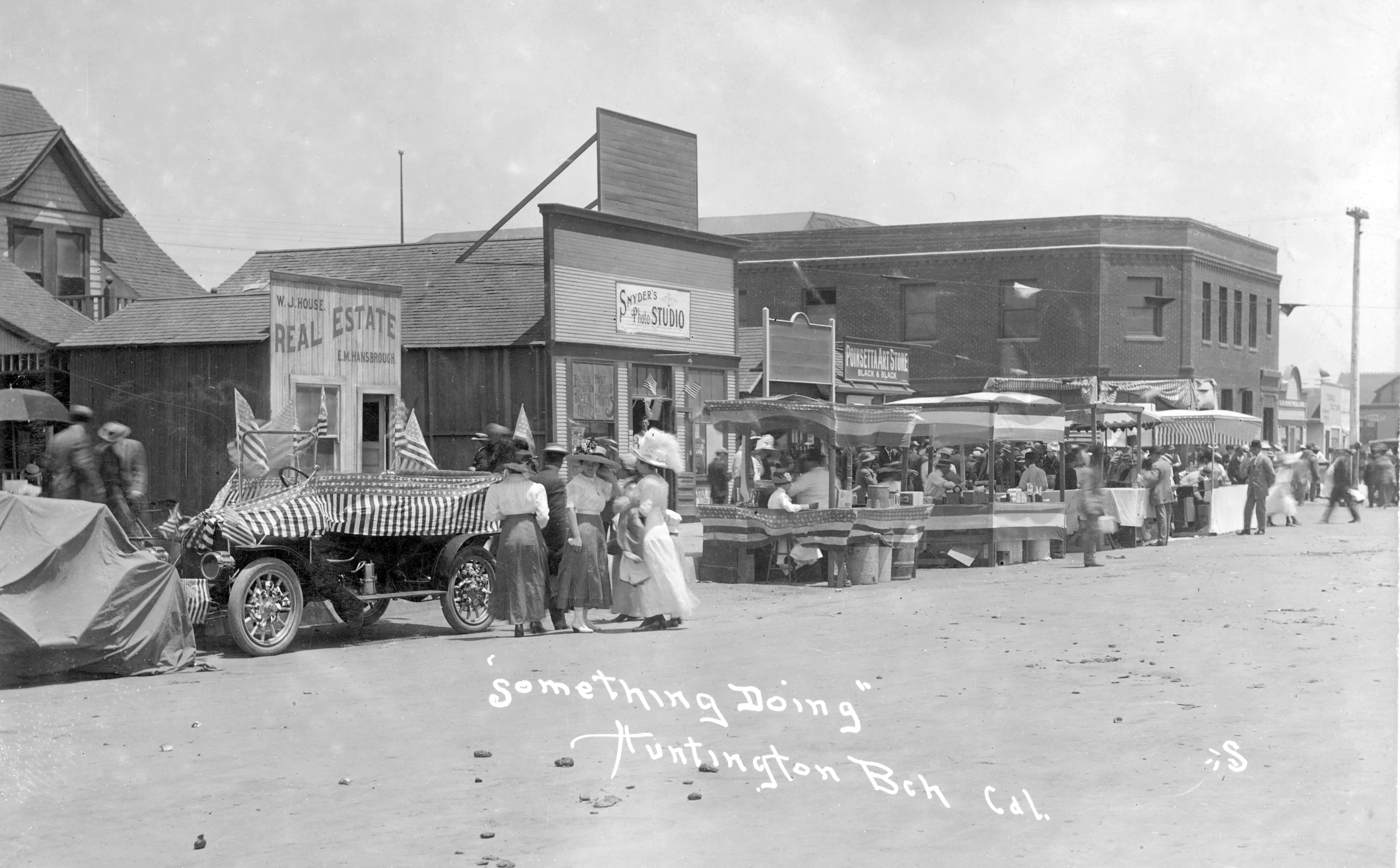 an old black and white po of people near a city street with a vintage car