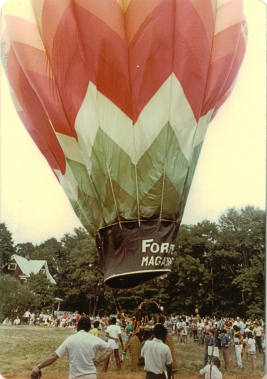 some people and a large colorful  air balloon