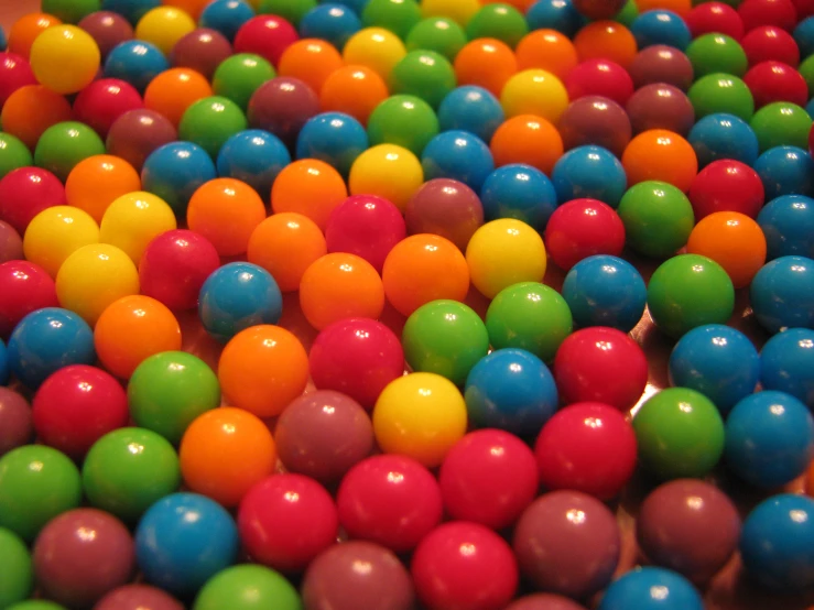 close up of multi - colored balls sitting in a bin