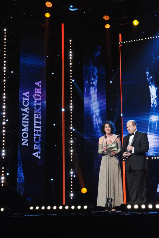 two people standing on stage at a television awards