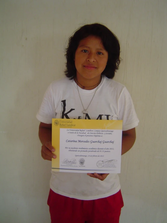 a boy is holding up a paper with the certificate on it