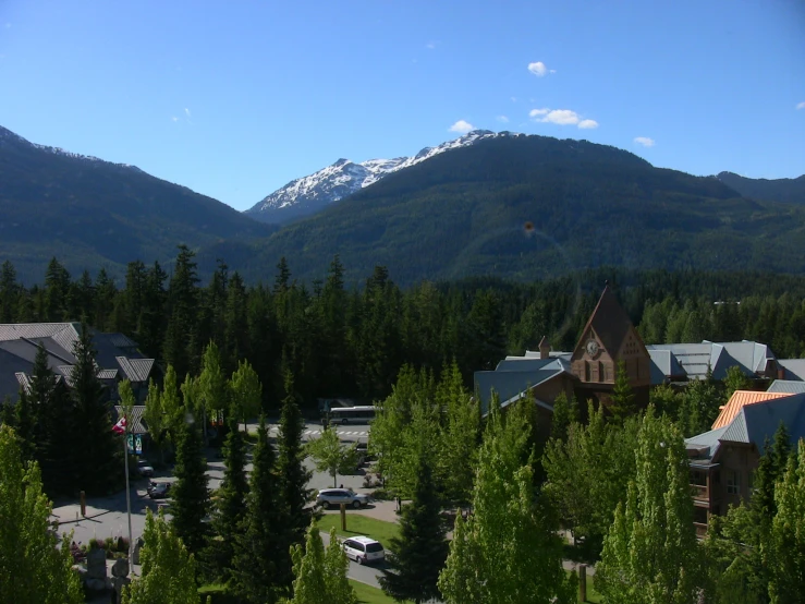 a mountain area with buildings and evergreens