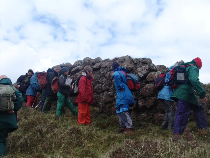 many people climbing up and down a grassy hill