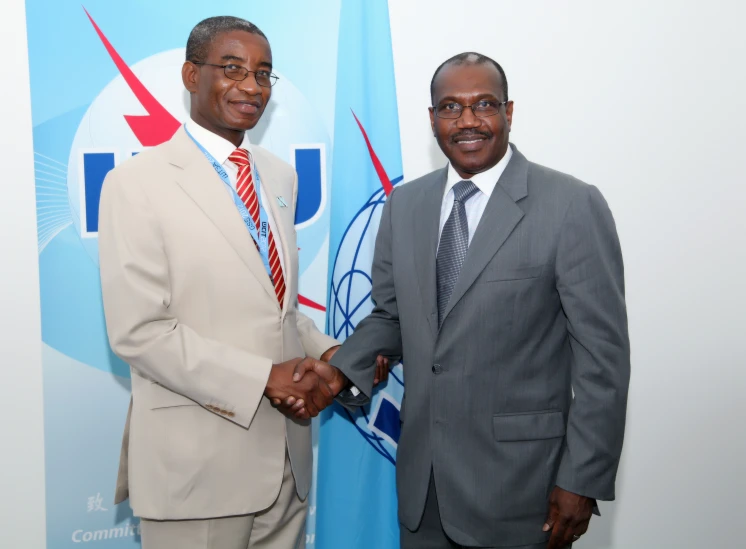 two businessmen in business suits greeting each other for a handshake