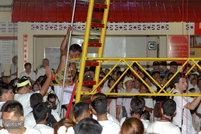 a crowd of people standing around a large ladder