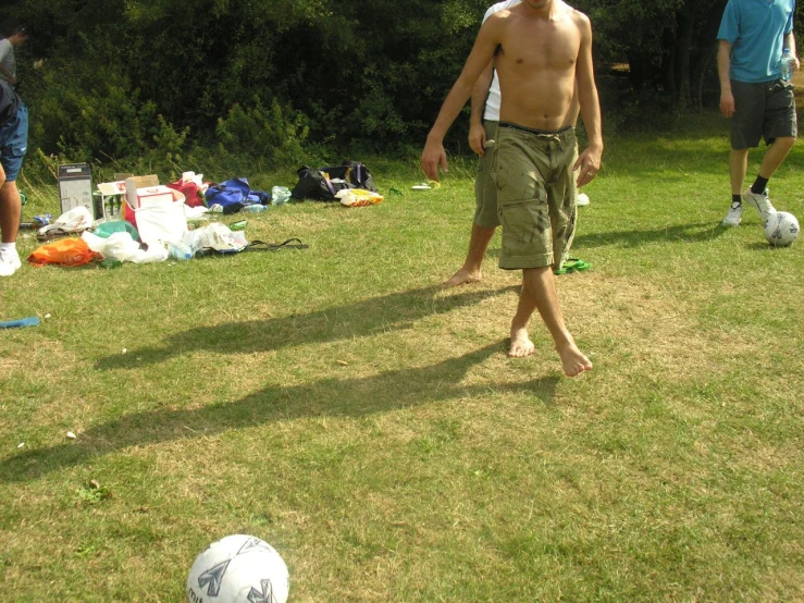 a shirtless man is playing ball in the yard