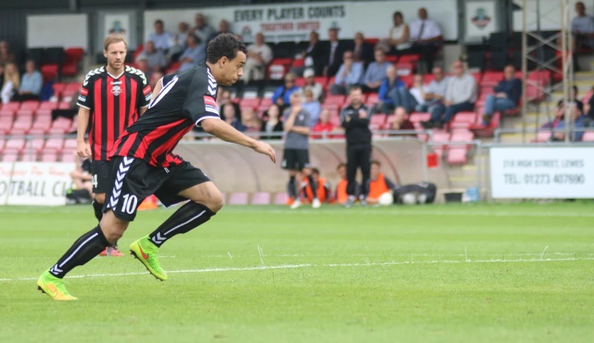 a soccer player kicking a ball in front of a crowd