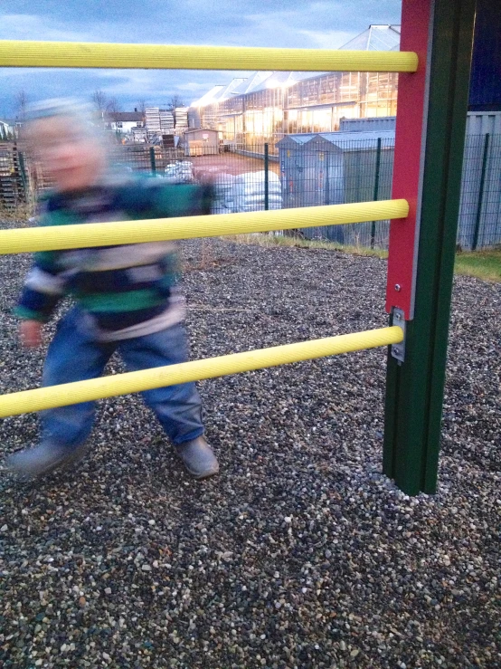 a child walking on a walkway by a playground