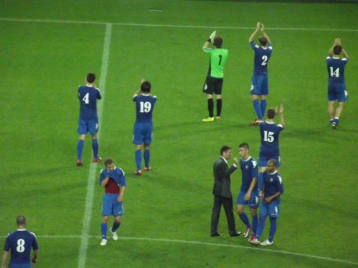 players stand on the field waving to each other