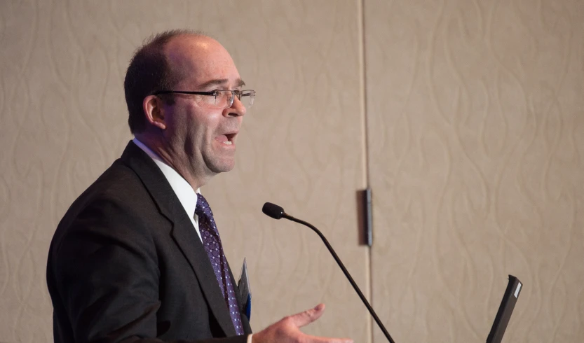 a bald man is speaking at an event