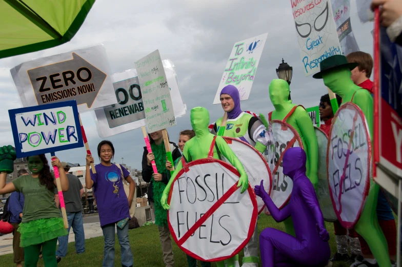 people protesting and carrying signs on the grass