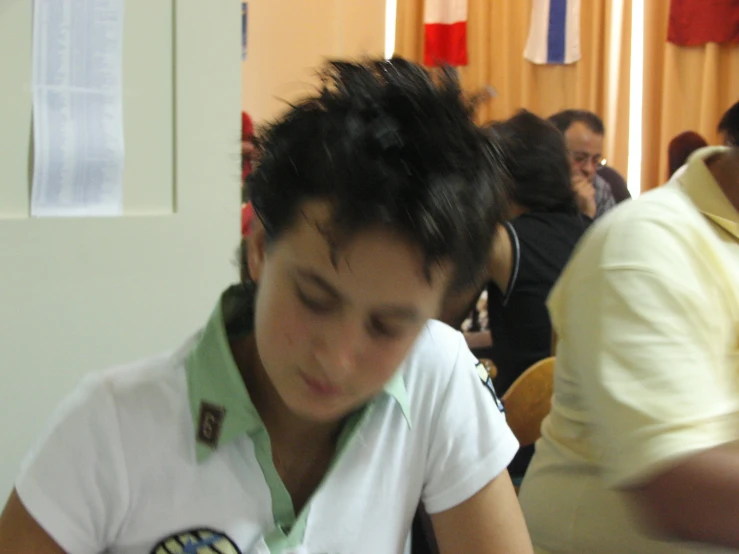 a woman sitting in front of another woman reading a book