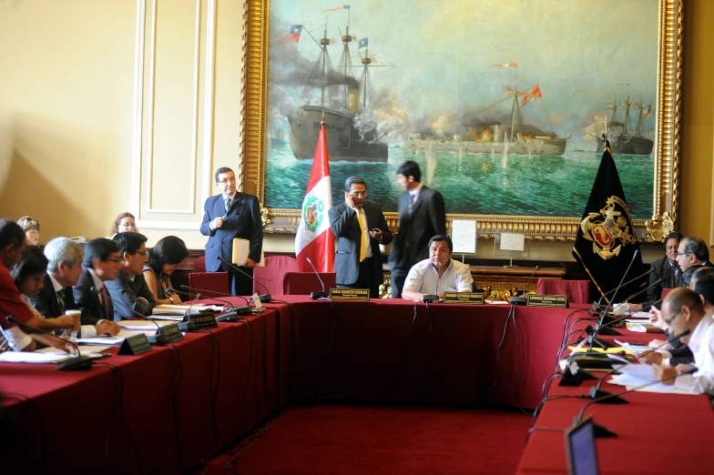 several people and two men are sitting at their desks