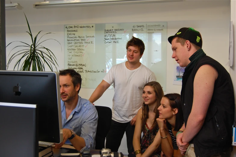 a group of people watching soing on the screen of a computer