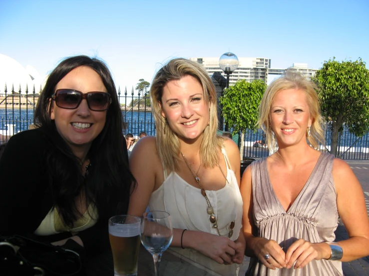 three beautiful women posing for a po at a cocktail