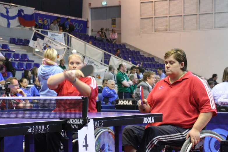 two men and a child play table tennis at a game