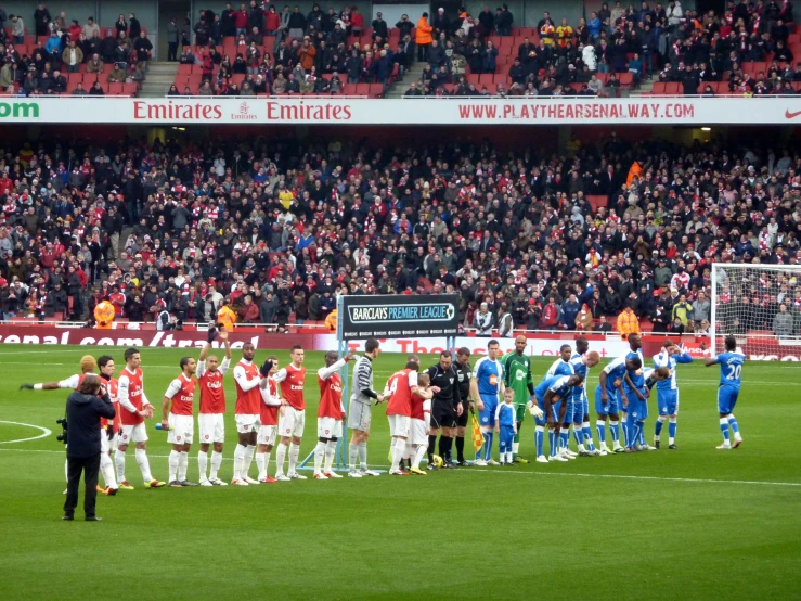 a group of people standing next to each other on a soccer field