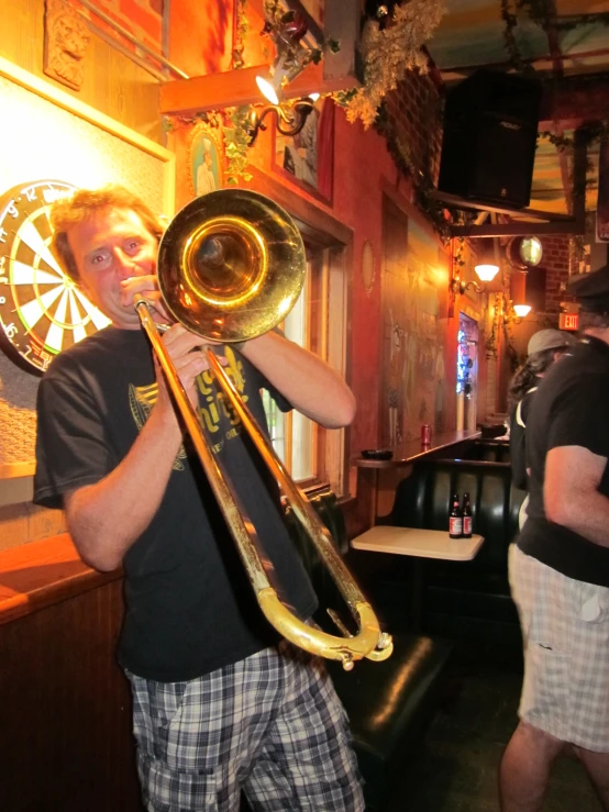 a man standing behind the bar with a trombone in his hand