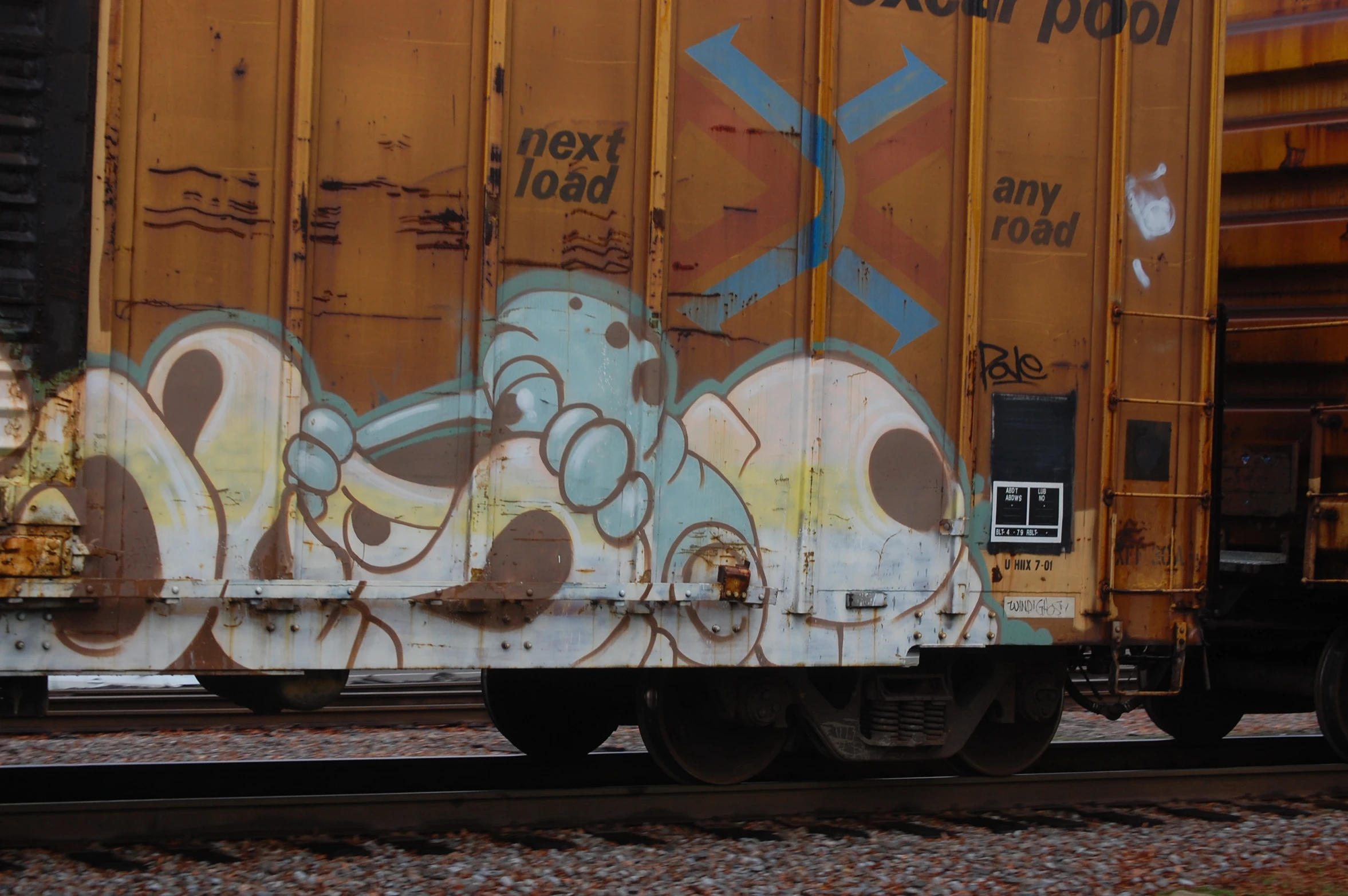 a graffiti covered train cart with a bunch of words painted on it