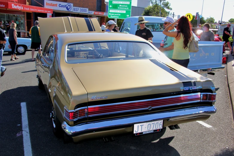 an antique car is parked in front of a crowd