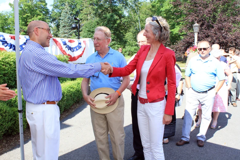 two people shaking hands while standing next to another man