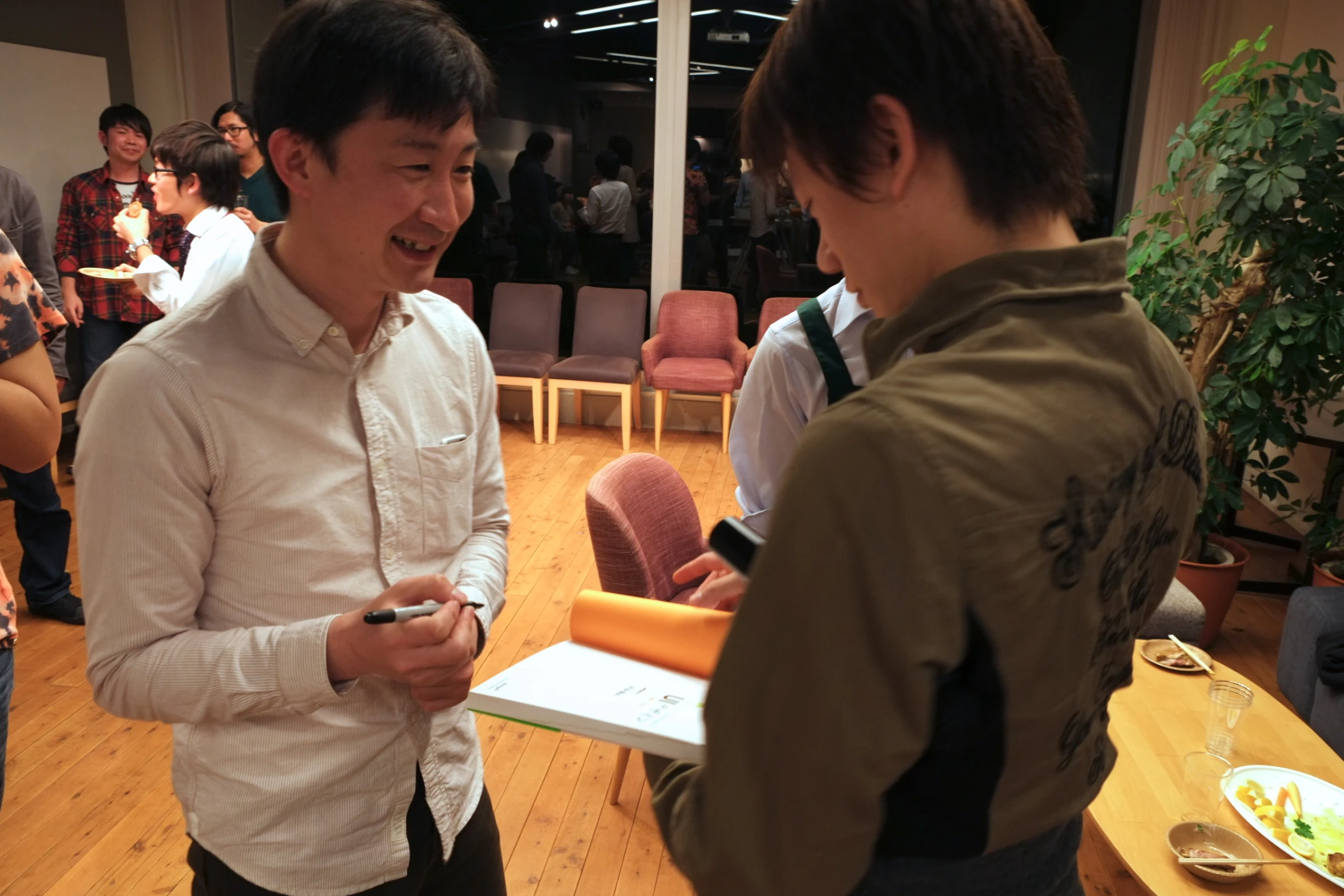 two men standing next to each other in a living room