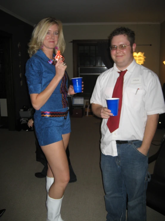 a woman in a short blue dress holding cups and a man