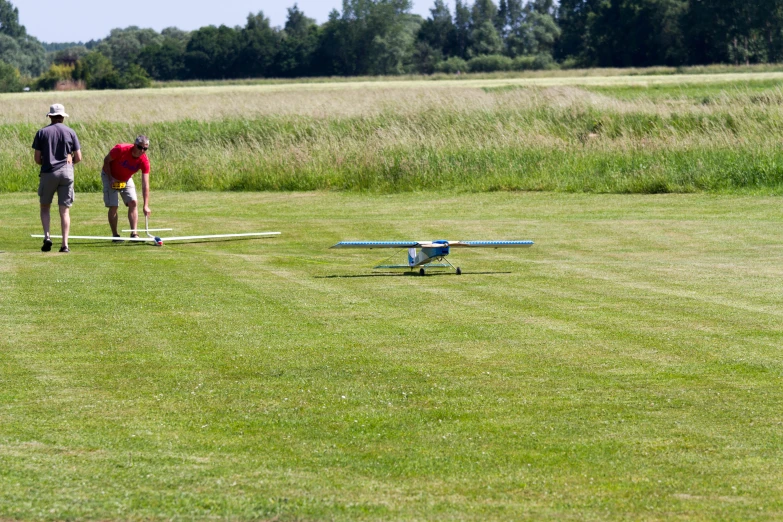 a man is standing behind two small planes on the field